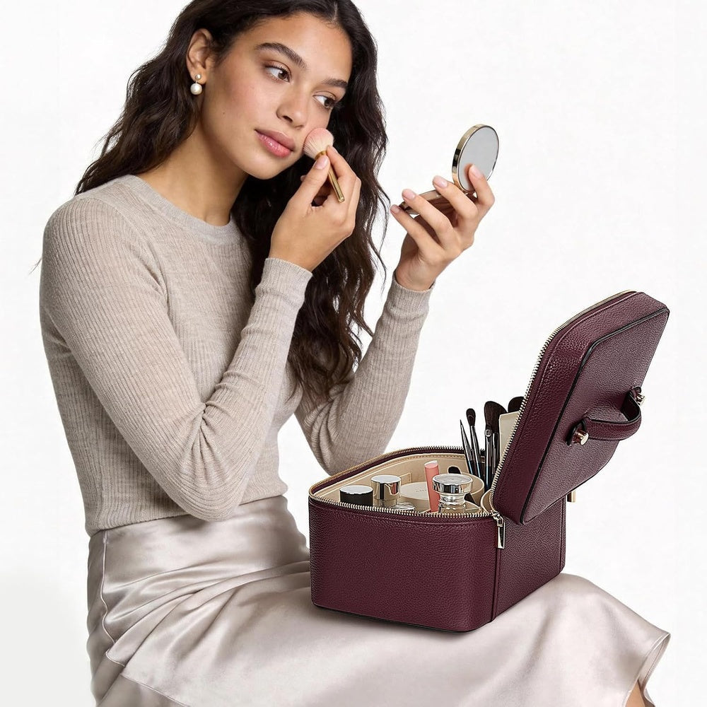 Make-up being applied at a table with the vanity case open nearby